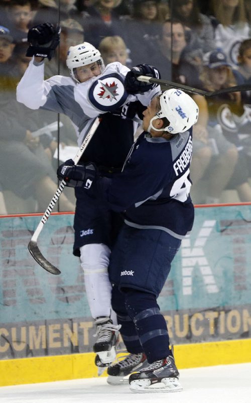 #45 Jimmy Lodge gets lifted off his skates by #92 Ralfs Freidergs  . SPORTS - Winnipeg Jets Development Camp scrimmaged in front of a standing room  crowd at the MTS Iceplex   Story by Ed Tait . July 11 2014 / KEN GIGLIOTTI / WINNIPEG FREE PRESS