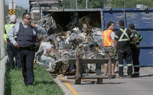 A large truck carrying crushed recycled metal has lost its load on Main St north of Hyw 101 causing traffic delays  RCMP and heavy equipment are on scene to begin cleanup-Breaking News- July 11, 2014   (JOE BRYKSA / WINNIPEG FREE PRESS)