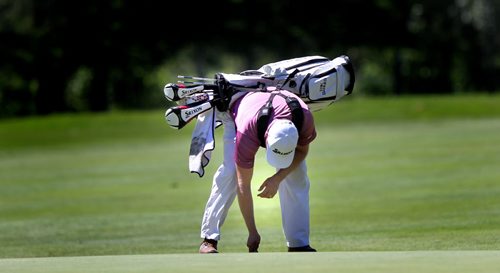 Carrying all his own tools, Erik Barnes takes a dent out of the tenth green before moving on to the 11th tee at Pine Ridge Friday afternoon. See Kyle's story. July 11, 2014 - (Phil Hossack / Winnipeg Free Press)