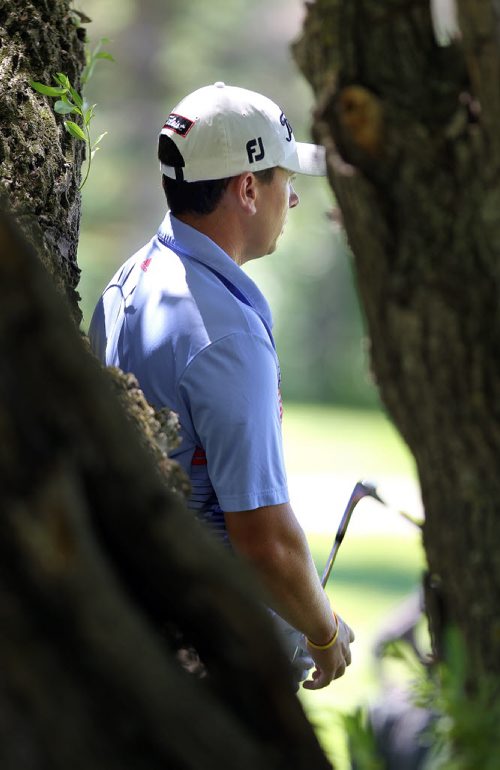 Joshua Creel looks out to the 11th green from deep inside a stand of willow trees figuring out how to swing in tight space after his ball rolled past the pin and into the trees at Pine Ridge Friday afternoon. See Kyle's story. July 11, 2014 - (Phil Hossack / Winnipeg Free Press)