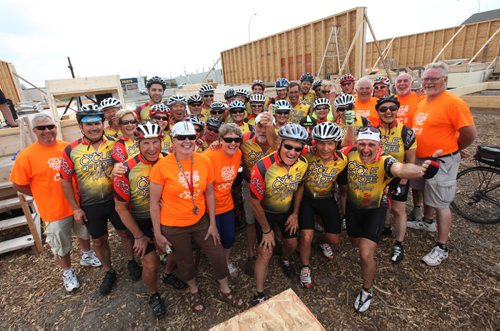 32 cyclists and members of their crew pose for a photo in front of the Habitat Home on Nairn Ave. that they help raise money for through a cyclotron. The  32 cyclist  rode 1000 miles and raised $170,000 for to build a Habitat home for a local family.   See Ashley Prest Story.  July 12, 2014 Ruth Bonneville / Winnipeg Free Press