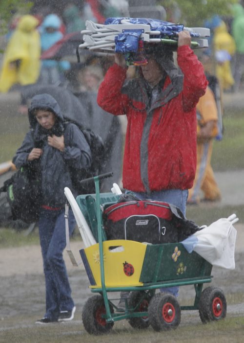 July 13, 2014 - 140713  -  Fans cover up on a very wet final day of Folk Fest Sunday, July 13, 2014. John Woods / Winnipeg Free Press