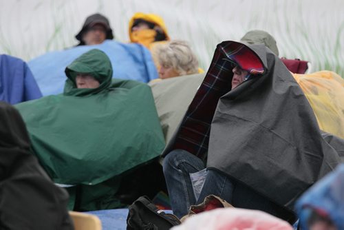 July 13, 2014 - 140713  -  Fans cover up on a very wet final day of Folk Fest Sunday, July 13, 2014. John Woods / Winnipeg Free Press