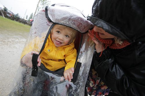 July 13, 2014 - 140713  -  Miriam Recksiedler and her mom Jillian check to see if the rain has stopped as music fans cover up on a very wet final day of Folk Fest Sunday, July 13, 2014. John Woods / Winnipeg Free Press