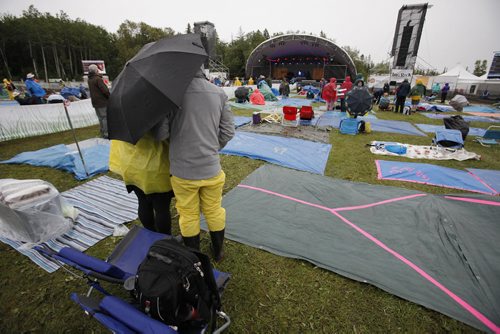 July 13, 2014 - 140713  -  Music fans cover up on a very wet final day of Folk Fest Sunday, July 13, 2014. John Woods / Winnipeg Free Press