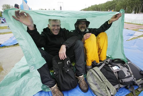 July 13, 2014 - 140713  -  Music fans and brothers Keith (L) and Lesly Derksen cover up on a very wet final day of Folk Fest Sunday, July 13, 2014. John Woods / Winnipeg Free Press