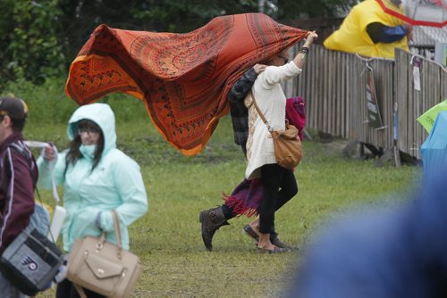 July 13, 2014 - 140713  -  Music fans cover up on a very wet final day of Folk Fest Sunday, July 13, 2014. John Woods / Winnipeg Free Press