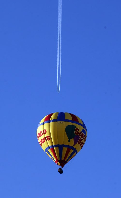 STDUP Äì Hot Air and Vapour Trails , the calm cool and clear sky  made conditions ideal for a sunrise hot air balloon ride across the city in a Sundance balloon. July 15 2014 / KEN GIGLIOTTI / WINNIPEG FREE PRESS