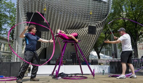 140716 Winnipeg - DAVID LIPNOWSKI / WINNIPEG FREE PRESS  Contortionist Lisa Lottie performs with the help of audience members Wednesday afternoon in Old Market Square for the official kick off to The Fringe Festival. Greg Jonuk  is on the left. Jim (no last name given) is on the right.