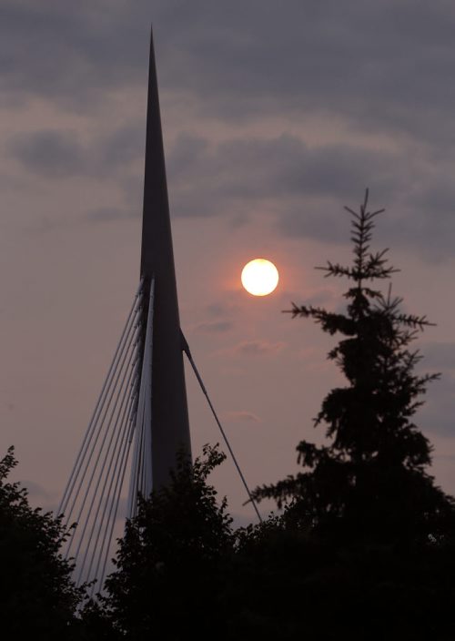 Stdup - Bringing the Heat  , a bright orange sun rose through  the haze over Esplanade Riel cable-stay ed bridge , today temps will rise to +30 degrees , sunny and hot .July 17 2014 / KEN GIGLIOTTI / WINNIPEG FREE PRESS
