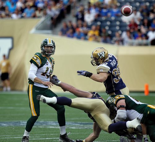 Edmonton Eskimo quarterback Mike Reilly gets the pass away against the Winnipeg defence Thursday evening at Investor's Field. See story. July 16, 2014 - (Phil Hossack / Winnipeg Free Press)