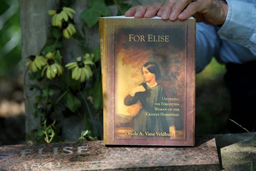 Oriole Vane Veldhuis holds her book next to her great- grandmother's grave Else.    Oriole Vane Veldhuis, author of For Elise, who has rescurrected the Criddle - Vane story with her research and depiction of Criddle's mistress Else Vane who was actually engaged to Criddle for  but who he never married.  49er feature on the Criddle family the park is named after. Percy Criddle, a somewhat wealthy merchant, arrived from London in 1882 with his wife and four children, and his German mistress Else and their five children.  They homesteaded in this weird arrangement, passing off his mistress as a widow who worked as the family maid. The provincial park still carries many of their effects, although vandals torched the home  about two weeks ago. Homestead is near Shilo Manitoba.  See Bill Redekop story.   July 16, 2014 Ruth Bonneville / Winnipeg Free Press