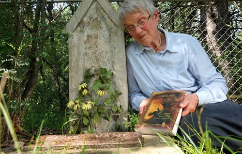 Oriole Vane Veldhuis holds her book next to her great- grandmother's grave Else.   Oriole Vane Veldhuis, author of For Elise, who has rescurrected the Criddle - Vane story with her research and depiction of Criddle's mistress Else Vane who was actually engaged to Criddle for  but who he never married.  49er feature on the Criddle family the park is named after. Percy Criddle, a somewhat wealthy merchant, arrived from London in 1882 with his wife and four children, and his German mistress Else and their five children.  They homesteaded in this weird arrangement, passing off his mistress as a widow who worked as the family maid. The provincial park still carries many of their effects, although vandals torched the home  about two weeks ago. Homestead is near Shilo Manitoba.  See Bill Redekop story.   July 16, 2014 Ruth Bonneville / Winnipeg Free Press