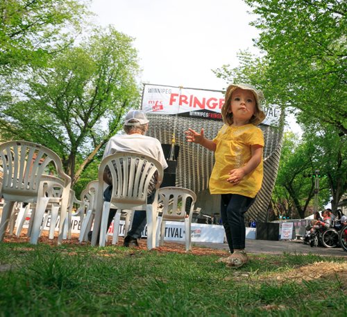 In Old Market Square Florence Tadeuszow, 20 months, waits for the first show of the day, the Exchange District Biz noon-hour series on the Cube Stage. 140718 - Friday, July 18, 2014 - (Melissa Tait / Winnipeg Free Press)