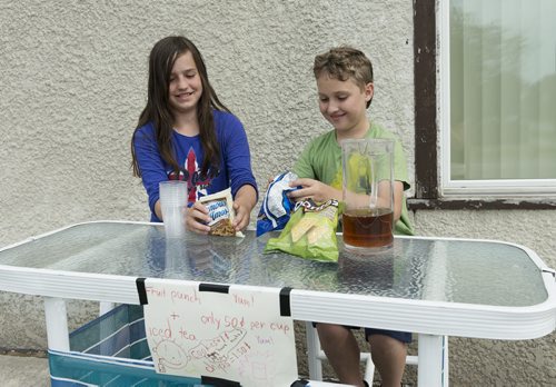 Yulia Kuzney, 11 and Tristin Harris, 11 have set up a stand at Roch Street and Bowman Avenue selling juice, cookies and chips since early June. They say it makes people, as well as themselves very happy. Sarah Taylor / Winnipeg Free Press July 18, 2014