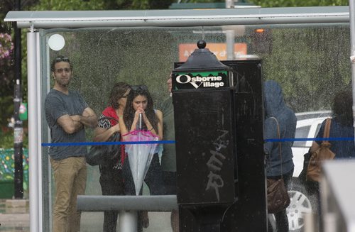 People take shelter in the bus terminal in Osborne Village Friday after the sudden down pour of rain. Sarah Taylor / Winnipeg Free Press July 18, 2014