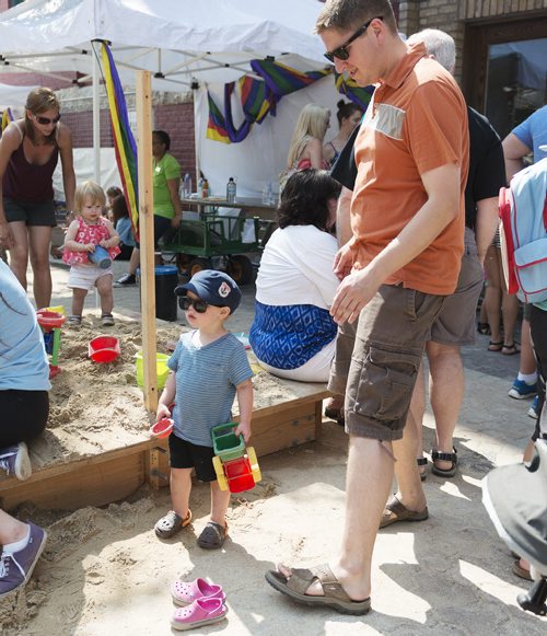 Samuel Mahe, 22 months, and his father Richard play in the sand pit at Fringe Fest on Saturday. Sarah Taylor / Winnipeg Free Press July 19, 2014