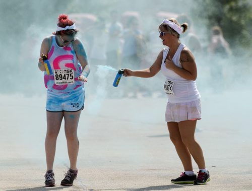 Justyce Strembel gets sprayed by her mother Jennifer at Colour Me Rad on Saturday at Assiniboia Downs. Sarah Taylor / Winnipeg Free Press July 19, 2014