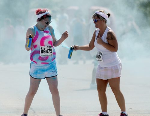 Justyce Strembel gets sprayed by her mother Jennifer at Colour Me Rad on Saturday at Assiniboia Downs. Sarah Taylor / Winnipeg Free Press July 19, 2014