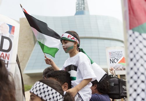Five year old Ahmad Zeid sits on his cousins shoulders as groups gather at the Canadian Museum for Human Rights on Saturday to free Palestine and end military assault on Gaza. Sarah Taylor / Winnipeg Free Press July 19, 2014