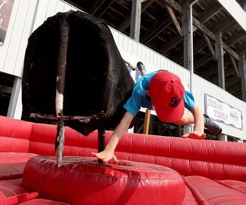 A youngster is tossed from the mechanical bull at the Morris Stampede in Morris, Manitoba, Saturday, July 19, 2014. (TREVOR HAGAN/WINNIPEG FREE PRESS)