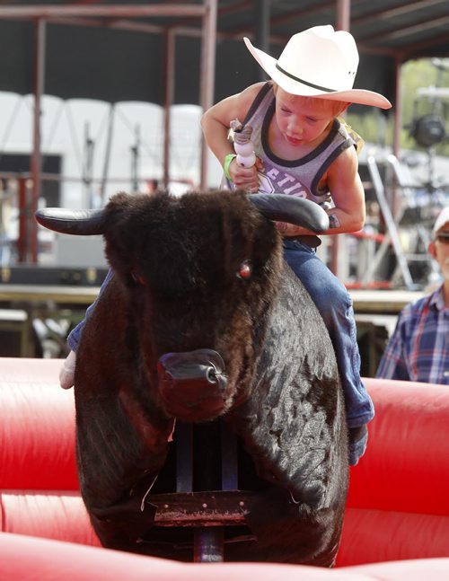 A youngster riding the mechanical bull at the Morris Stampede in Morris, Manitoba, Saturday, July 19, 2014. (TREVOR HAGAN/WINNIPEG FREE PRESS)