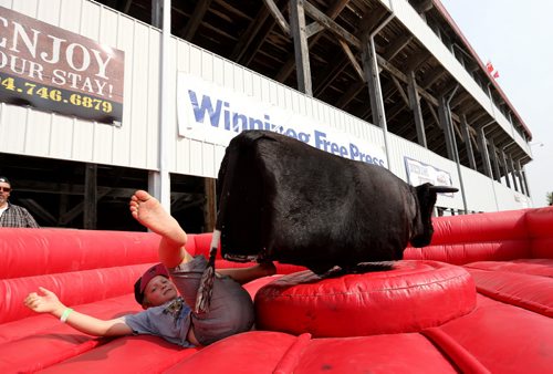 Xavier Laviolette, 8, is thrown from a mechanical bull at the Morris Stampede in Morris, Manitoba, Saturday, July 19, 2014. (TREVOR HAGAN/WINNIPEG FREE PRESS)