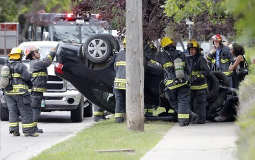 MVC rollover sent a can over a sidewalk with minor injuries to the driver  , slowing traffic on Erin St between Wellington Ave and Sargent Ave  during the afternoon rush hour . July 21 2014 / KEN GIGLIOTTI / WINNIPEG FREE PRESS