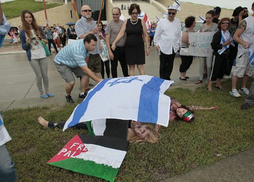 July 21, 2014 - 140721  -  An Israel supporter places a flag over Palestinian supporters who were taking part in a "die-in" as about 100 people gather for a pro-Israel rally in downtown Winnipeg Monday, July 21, 2014. John Woods / Winnipeg Free Press