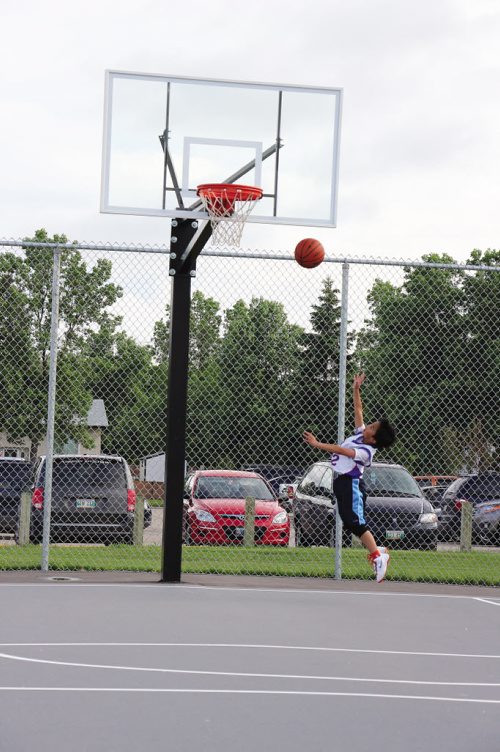 Canstar Community News July 23/14 - A young basketball player completes the first official basket at the Oxford Heights Community Club basketball court. (HERALD/SUPPLIED/OXFORD HEIGHTS COMMUNITY CLUB)