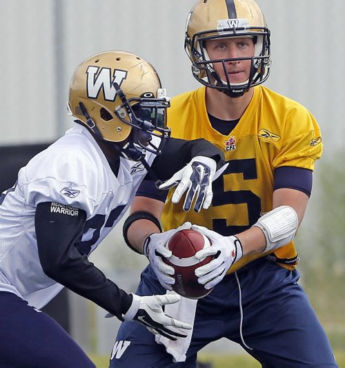 QB Drew Willy hands off to RB #32 Nic Grigsby .The running game has dropped off in the last game .  Wpg Blue Bomber prepare for Friday's game in Vancouver vs the BC Lions  July 23 2014 / KEN GIGLIOTTI / WINNIPEG FREE PRESS