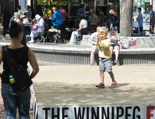 Zac Friesen, 4, gets excited for his first Fringe show as he dances on the stage at Old Market Square with his mother Shauna Evans on Wednesday. Sarah Taylor / Winnipeg Free Press July 23, 2014