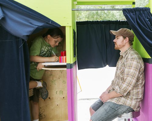 Tait Palsson, 10, draws Collin Zipp, 36, in the photobooth run by kids, set up by Art City at the Fringe Festival on Wednesday. Artistic director Eddie Ayoub says they've had this idea for years but this is the first time they've done it. Sarah Taylor / Winnipeg Free Press July 23, 2014