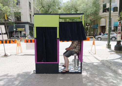 Collin Zipp, 36, sits in the photobooth run by kids, set up by Art City at the Fringe Festival on Wednesday. Artistic director Eddie Ayoub says they've had this idea for years but this is the first time they've done it. Sarah Taylor / Winnipeg Free Press July 23, 2014