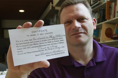 49.8  Korey Dyck, Director of the Mennonite Heritage Centre with a photocopy of Rev. David M. Stoesz's WW1 exemption card. (The original card is at the Canadian War Museum.) Kevin Rollason story.  Wayne Glowacki / Winnipeg Free Press July 24  2014