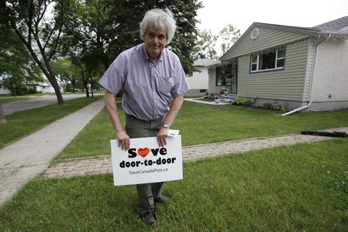 July 24, 2014 - 140724  -  Glenn Michalchuck posts a sign on his lawn to support door-to-door mail delivery instead of the proposed Canada Post  community mailboxs in Winnipeg Thursday, July 24, 2014.  John Woods / Winnipeg Free Press