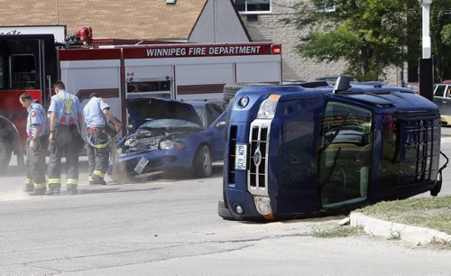 Firefighters pour sand on spilled fuild .Stdup 2 vehicle MVC car vs van rollover on St. Mary's Rd at Niverville Ave. Sent one person to hospital . July 25 2014 / KEN GIGLIOTTI / WINNIPEG FREE PRESS