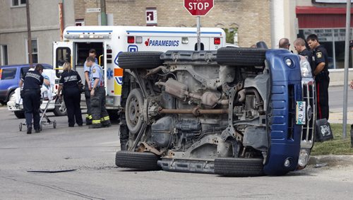 Paramedic transport injured driver .Stdup 2 vehicle MVC car vs van rollover on St. Mary's Rd at Niverville Ave. Sent one person to hospital . July 25 2014 / KEN GIGLIOTTI / WINNIPEG FREE PRESS
