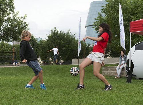 Ben Vanson, 9, plays against FIFA Women's World Cup volunteer Melissa Olivaers at the Forks for Folklorama Kick-Off while he visits from Vancouver. Sarah Taylor / Winnipeg Free Press July 26 2014