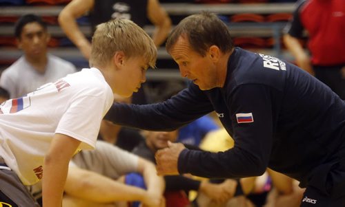 Sports .(left)  Russian Olympic Wrestler Sergei Belogazov puts on wrestling camp , demonstrating moves for the group with Gryphon Lalonde . July 28 2014 / KEN GIGLIOTTI / WINNIPEG FREE PRESS