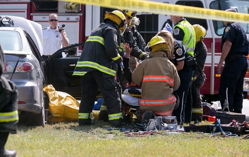 Firefighters used the jaws of life to free two people from a car after a two-car collision at Inkster Blvd and Fife St Tuesday morning. Two people were taken to hospital. 140729 - Tuesday, July 29, 2014 - (Melissa Tait / Winnipeg Free Press)