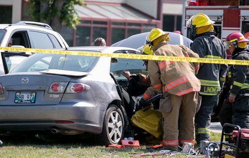 Firefighters used the jaws of life to free two people from a car after a two-car collision at Inkster Blvd and Fife St Tuesday morning. Two people were taken to hospital. 140729 - Tuesday, July 29, 2014 - (Melissa Tait / Winnipeg Free Press)