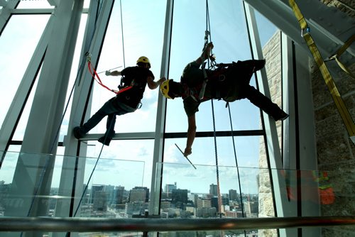 High Rise window washers with Picture Perfect Window Cleaning wash the windows in the Hope Tower in the Canadian Museum for Human Rights Tuesday afternoon all in preparation for the grand opening which is less than 2 months away.   See Murray McNeil's story.  Names - Silas Chipelski (left) and Robyn Hendrickson.  July 29, 2014 Ruth Bonneville / Winnipeg Free Press