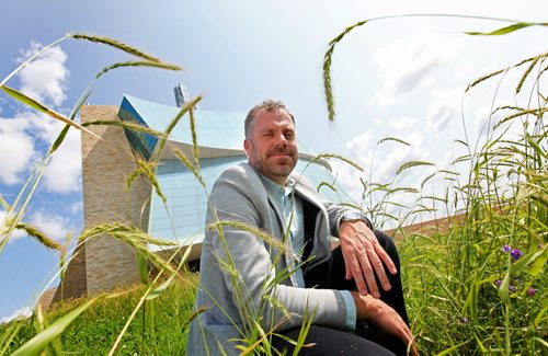 Bob Somers, landscape architects with Scatliff + Murray Inc. crouches with tall prairie grass surrounding him which has been planted around the outskirts of the Canadian Museum for Human Rights to keep in in context to Manitoba's prairie landscape.  See Kevin Rollason's story.   July 29, 2014 Ruth Bonneville / Winnipeg Free Press