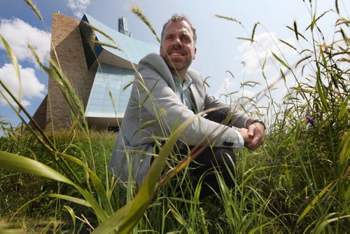 Bob Somers, landscape architects with Scatliff + Murray Inc. crouches with tall prairie grass surrounding him which has been planted around the outskirts of the Canadian Museum for Human Rights to keep in in context to Manitoba's prairie landscape.  See Kevin Rollason's story.   July 29, 2014 Ruth Bonneville / Winnipeg Free Press