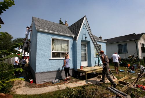 Take Pride Winnipeg and Monsanto Canada workers give home on Talbot Ave. a makeover Wednesday by painting the entire exterior as well as replacing front steps and adding other small fix ups to the home which was selected based on physical restraints of home owner  Standup photo July 30, 2014 Ruth Bonneville / Winnipeg Free Press