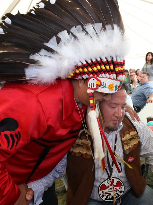 Derek Nepinak is hugged by a long line of Manitoba chiefs after being re-voted in the first ballot as the Grand Chief for the Assemble of Manitoba Chiefs Wednesday afternoon See Alex Paul Story- July 30, 2014   (JOE BRYKSA / WINNIPEG FREE PRESS)