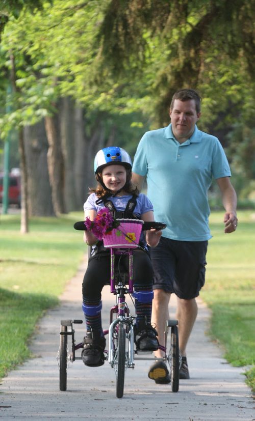10 yr old Waverley Leduc  with her special needs specially designed custom bike made by a Winnipeg manufacturer rides it in front of her River Heights home with her father Jamie giving chase.  See Adam Wazny story- July 31, 2014   (JOE BRYKSA / WINNIPEG FREE PRESS)