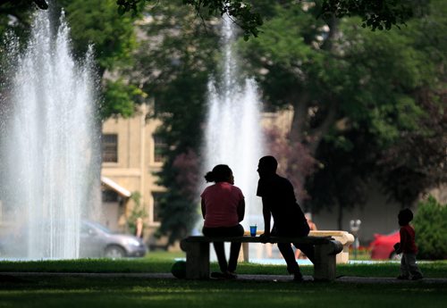 A family in the shade of a tree at the fountain in Memorial Park on Friday afternoon. 140801 - Friday, August 01, 2014 - (Melissa Tait / Winnipeg Free Press)