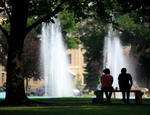 A couple in the shade under a tree at the fountain in Memorial Park Friday afternoon. 140801 - Friday, August 01, 2014 - (Melissa Tait / Winnipeg Free Press)